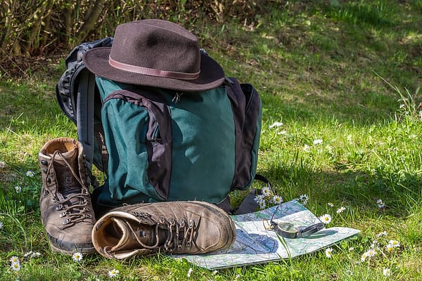 Back pack and a shoe on the ground together with a map